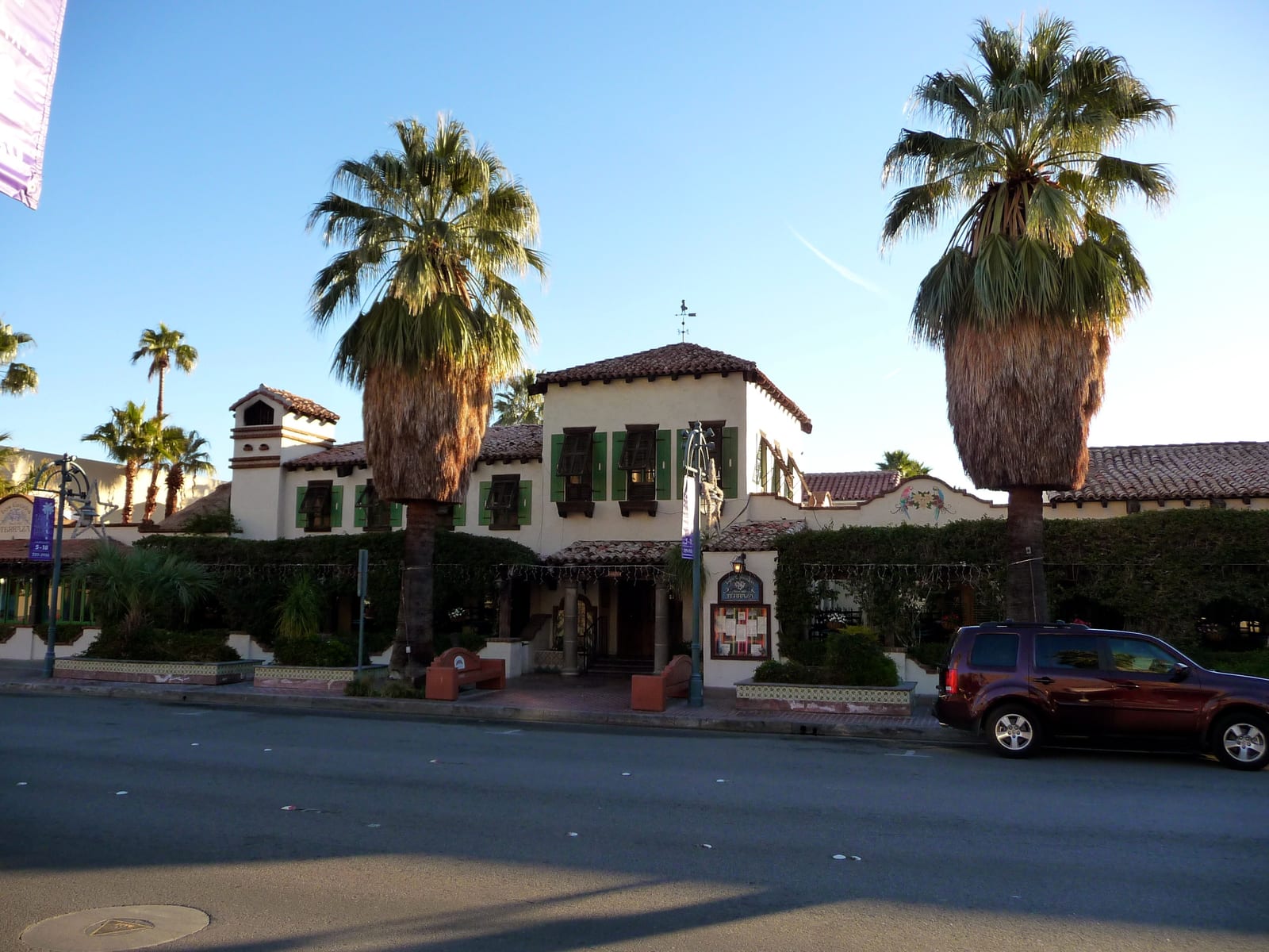 Spanish-style building and fan palms along a street in downtown Palm Springs, California